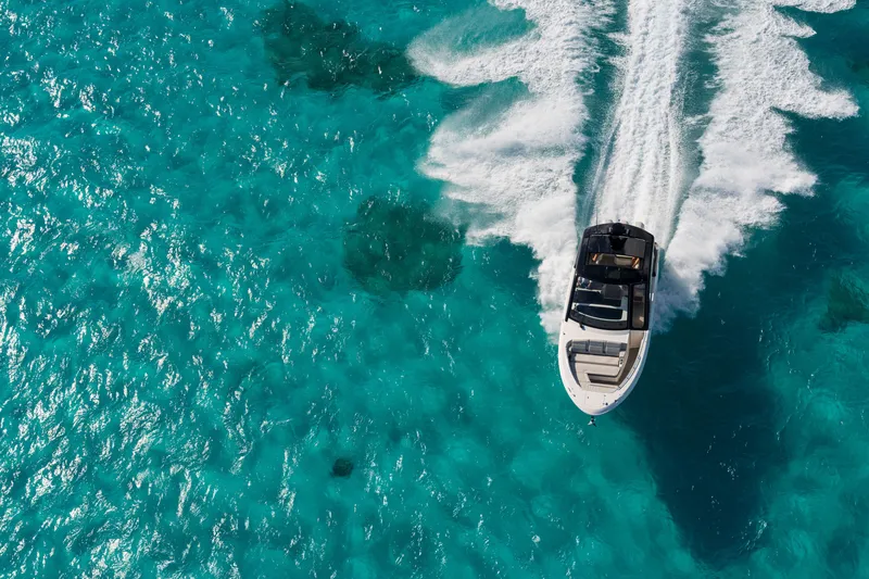Slide: The Image of A 2026 Sea Ray Sundancer 370 Outboard speeds across turquoise water. - 8
