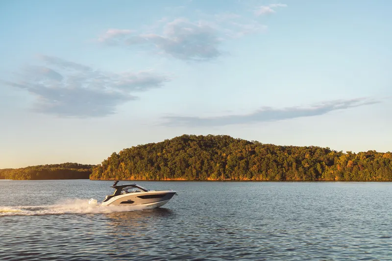 Slide: The Image of A Sea Ray Sundancer 370 Outboard cruising on calm waters with a wooded island in the background. - 30