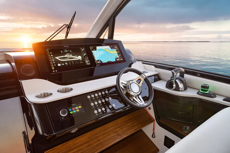 Slide: The Image of The cockpit of a Sea Ray Sundancer 370 Outboard with modern instruments and a stunning sea view. - 18