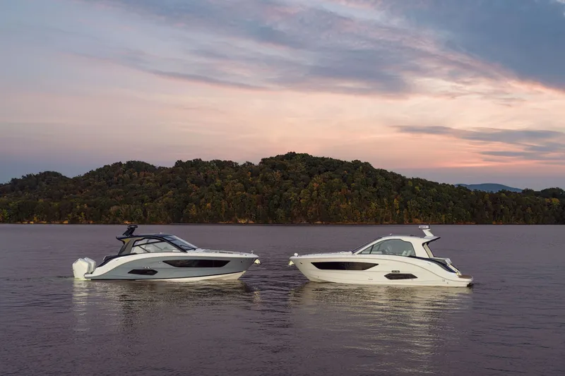 Slide: The Image of Two Sea Ray Sundancer 370 Outboard boats float on calm water at sunset. - 37