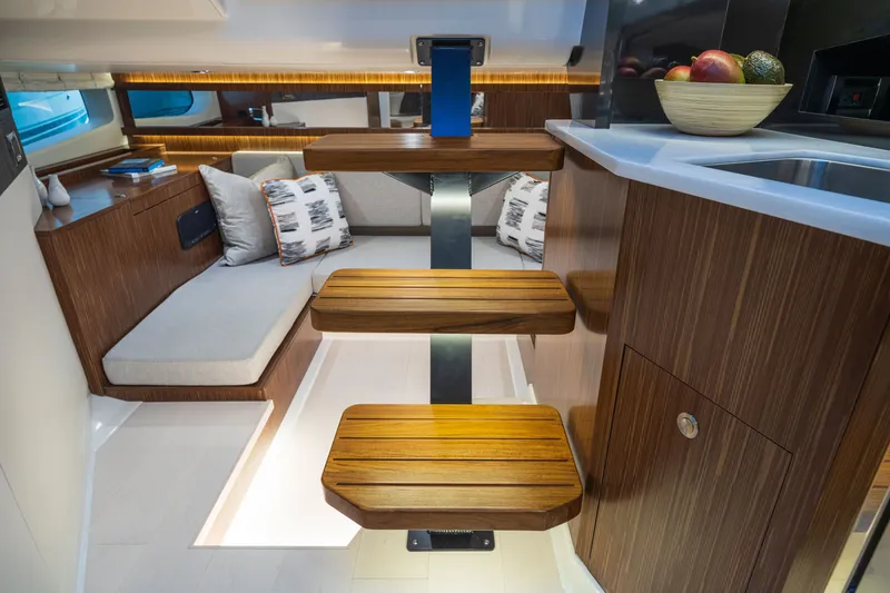 Slide: The Image of Interior of the 2026 Sea Ray Sundancer 370 Outboard with modern wooden steps and cozy seating area. - 17