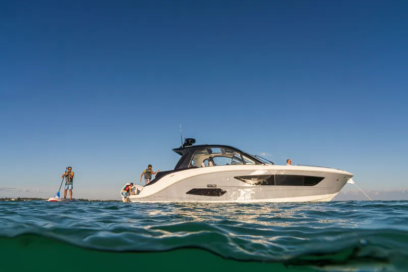 Slide: The Image of A 2026 Sea Ray Sundancer 370 Outboard on calm water with people on board. - 21