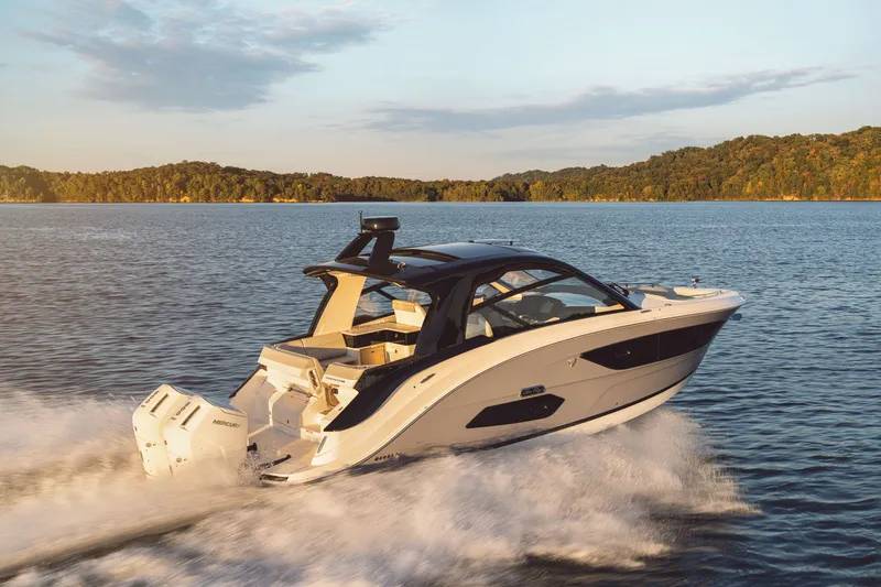 Slide: The Image of 2026 Sea Ray Sundancer 370 Outboard cruising on a calm lake at sunset. - 33