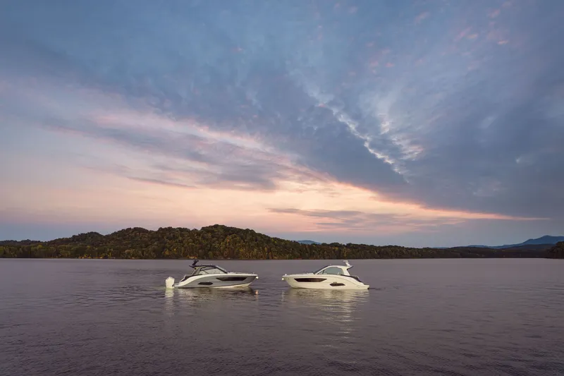 Slide: The Image of Two Sea Ray Sundancer 370 Outboard boats on a calm lake at sunset. - 36