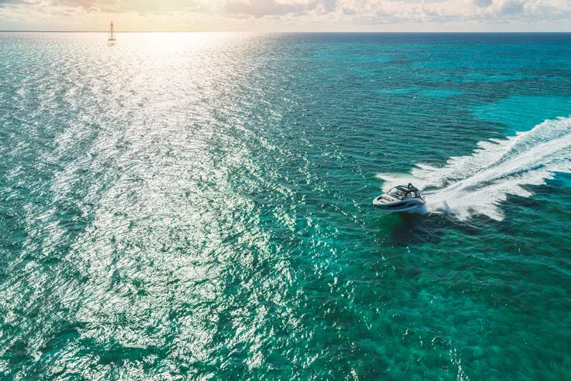 Slide: The Image of A Sea Ray Sundancer 370 Outboard speeds across sparkling turquoise water. - 9