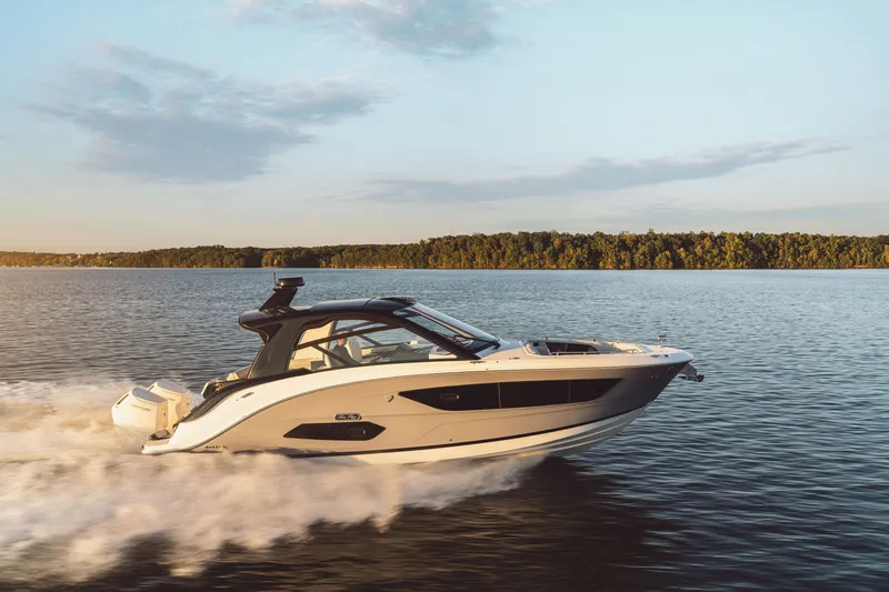 Slide: The Image of A 2026 Sea Ray Sundancer 370 Outboard speeds across calm water at sunset. - 29