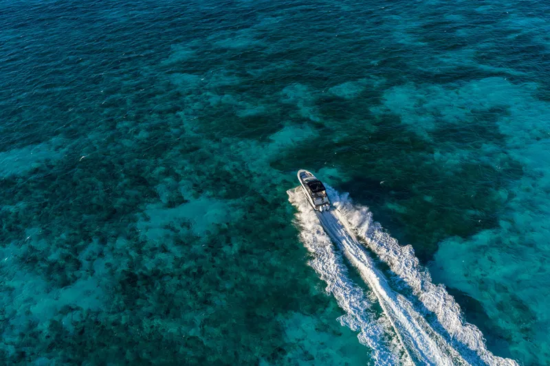 Slide: The Image of A 2026 Sea Ray Sundancer 370 Outboard speeds across clear, blue water. - 12