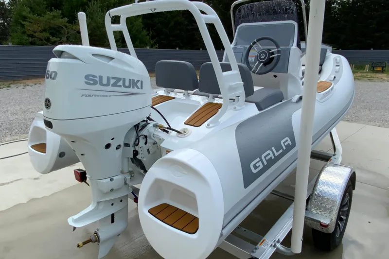 Slide: The Image of Gala V420 boat with Suzuki engine on trailer, 2027 model, parked outdoors. - 12