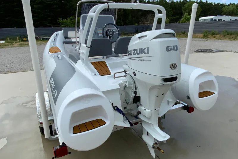 Slide: The Image of 2027 Gala V420 boat with Suzuki 60 outboard motor, parked on a trailer. - 14