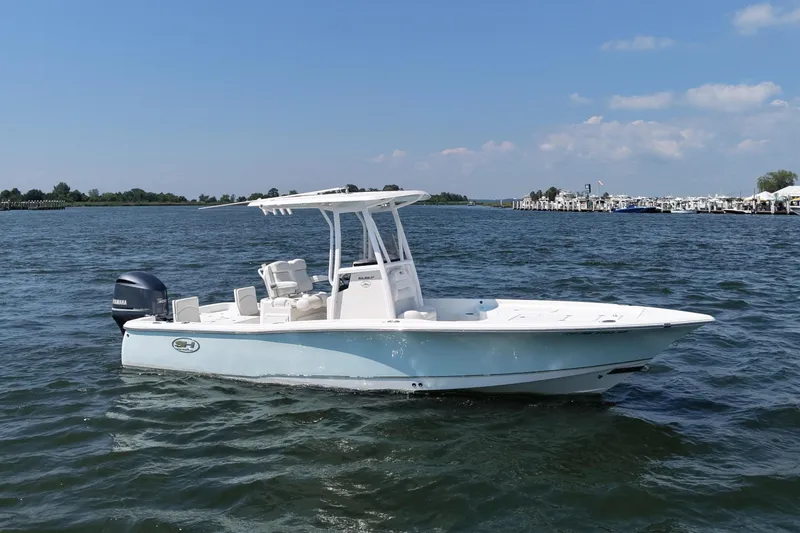 The Image of A 2017 Sea Hunt BX 25 BR boat floats on calm water under a blue sky. - 0