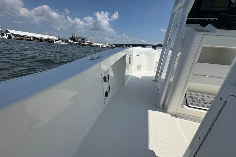 Slide: The Image of 2017 Sea Hunt BX 25 BR boat on water, clear sky, dock in background. - 12