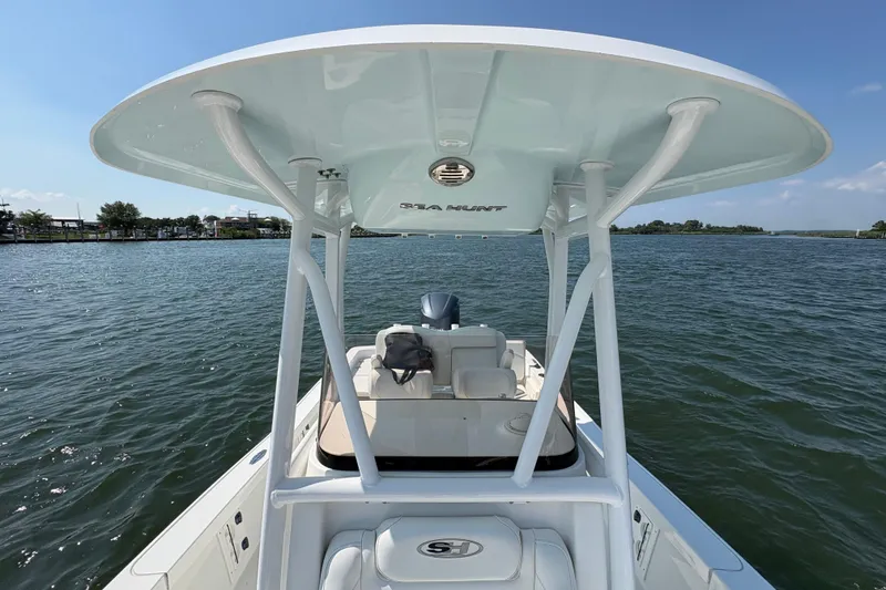 Slide: The Image of 2017 Sea Hunt BX 25 BR boat on calm water, featuring a sleek design and spacious deck. - 11