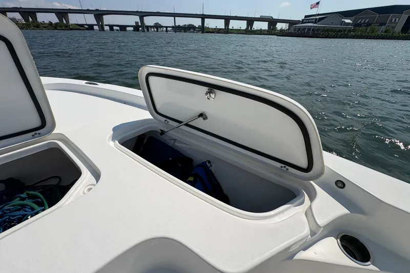 Slide: The Image of 2017 Sea Hunt BX 25 BR boat with open storage compartments on a sunny day. - 14