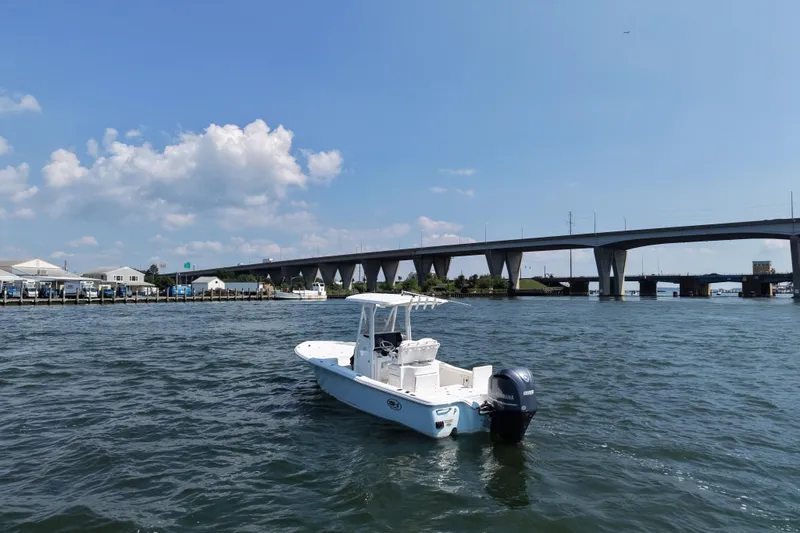 Slide: The Image of 2017 Sea Hunt BX 25 BR boat on water near a bridge under a clear sky. - 3