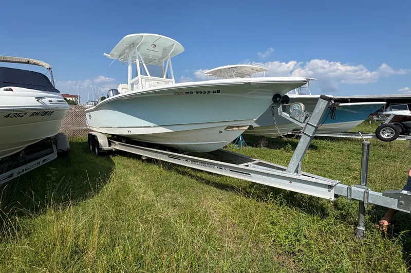 Slide: The Image of 2017 Sea Hunt BX 25 BR boat on trailer, parked on grass under blue sky. - 17