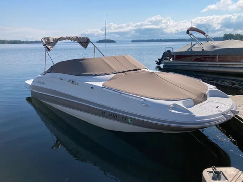 Slide: The Image of A white boat with gray covers is docked on a calm lake. - 7