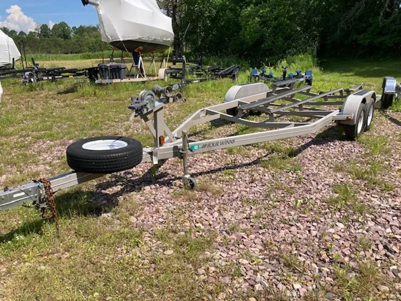 Slide: The Image of Boat trailer on a gravel lot with trees in the background. - 10