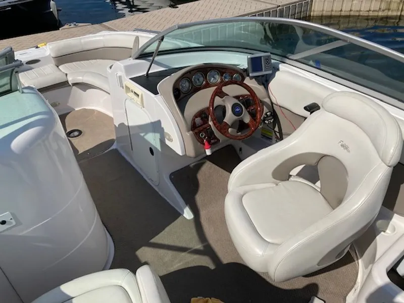 Slide: The Image of The image shows the cockpit of a 2003 Four Winns 214 Funship with white seats and a wooden steering wheel. - 4