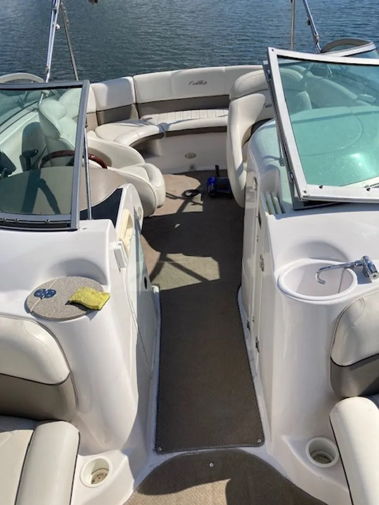 Slide: The Image of The image shows the cockpit of a 2003 Four Winns 214 Funship boat with beige seating. - 2