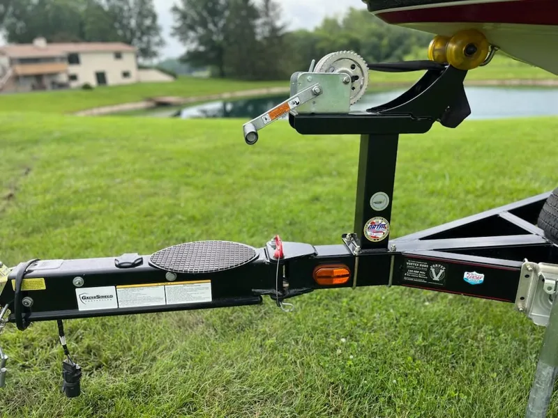 Slide: The Image of A boat trailer with a winch is on a grassy lawn near a pond. - 17