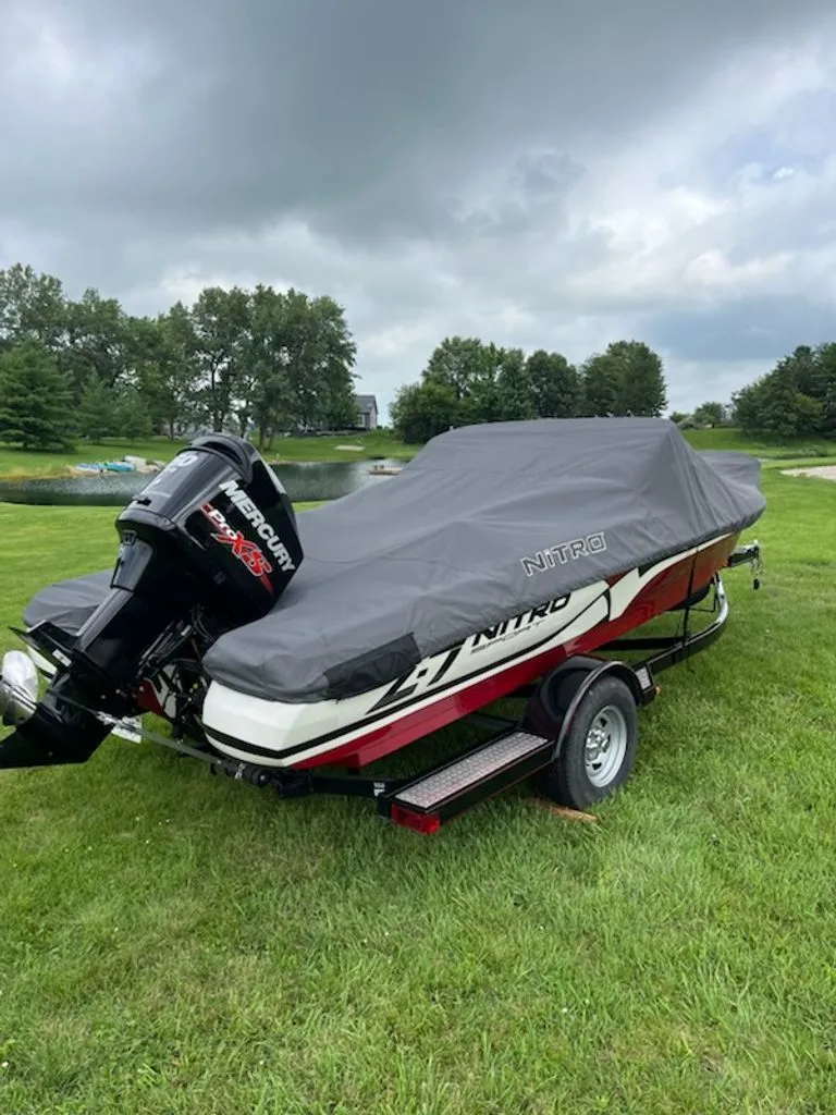 Slide: The Image of A 2015 Nitro Z-7 Sport boat with a cover sits on a trailer on a grassy area. - 27