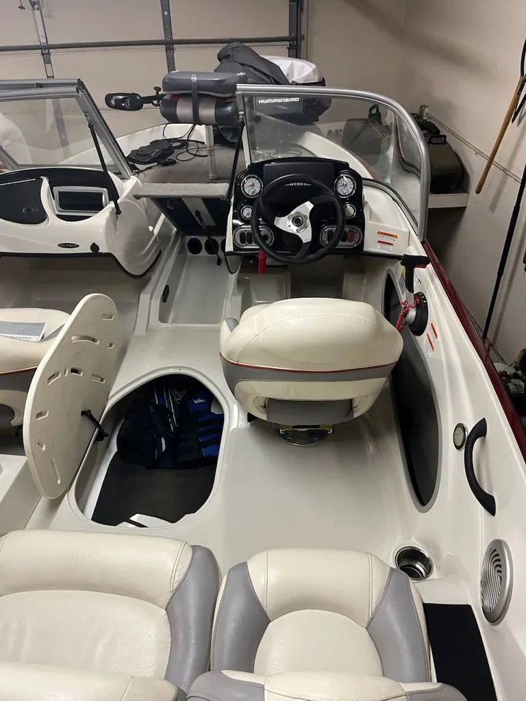 Slide: The Image of Interior view of a 2015 Nitro Z-7 Sport boat with white seats and a black steering wheel. - 6