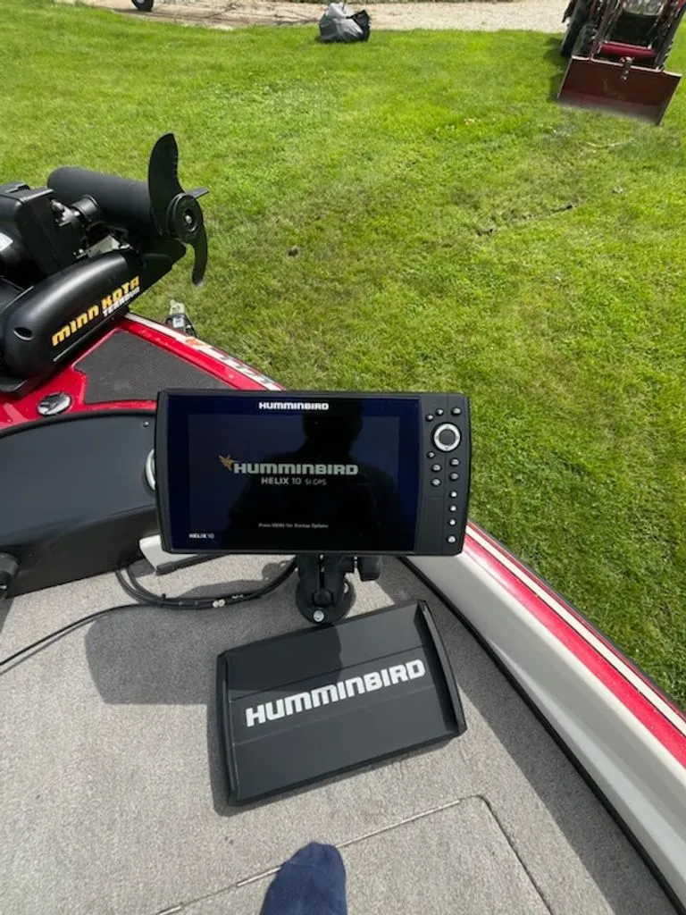 Slide: The Image of A Humminbird fish finder is mounted on a boat, surrounded by green grass. - 11