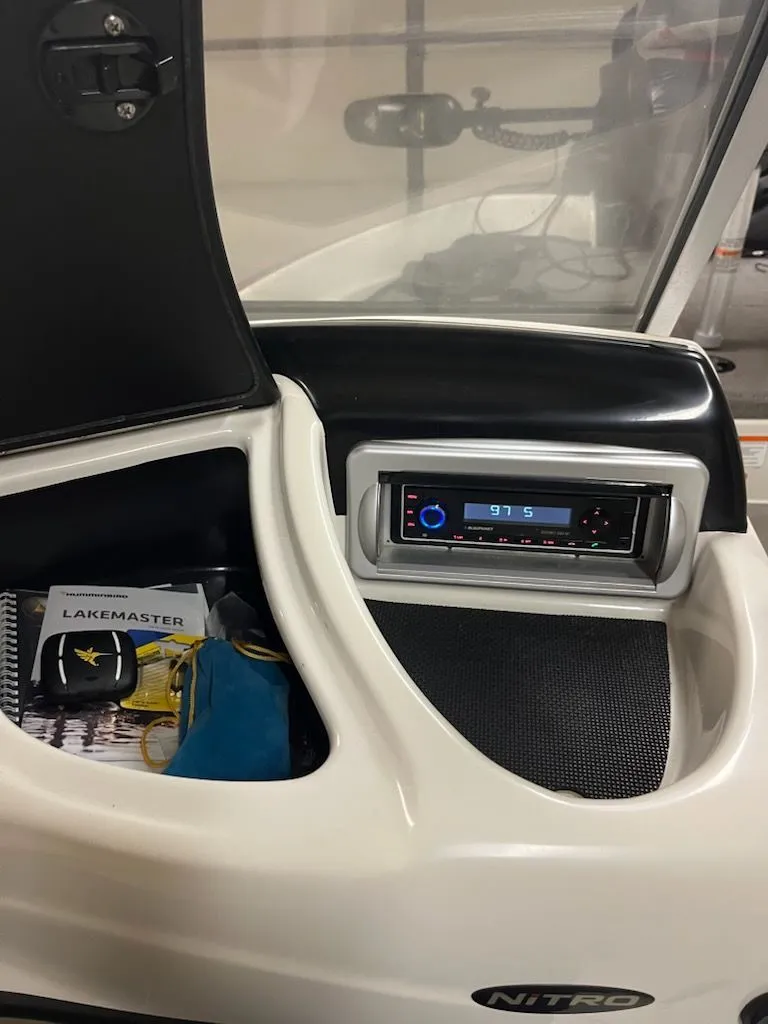 Slide: The Image of The image shows the dashboard of a Nitro Z-7 Sport boat with a radio and storage compartment. - 7