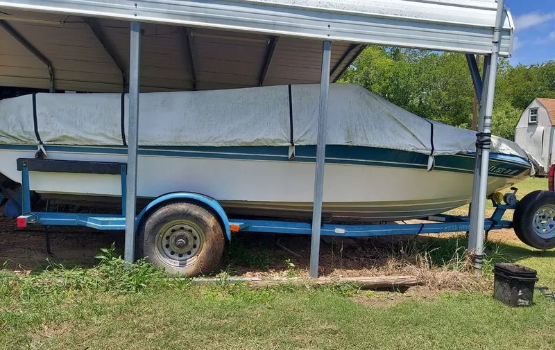 Slide: The Image of A 1992 Four Winns 190 Horizon on a trailer, parked under a carport. - 7