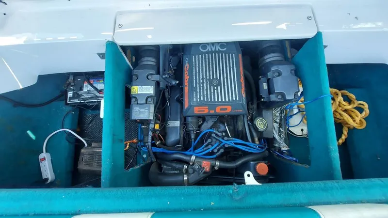 Slide: The Image of Engine compartment of a 1992 Four Winns 190 Horizon with OMC 5.0 engine, surrounded by blue carpet. - 8