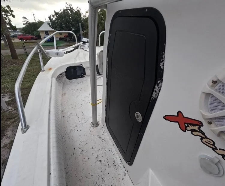 Slide: The Image of 2004 Twin Vee 26 Center Console boat deck with storage compartment and railing. - 20