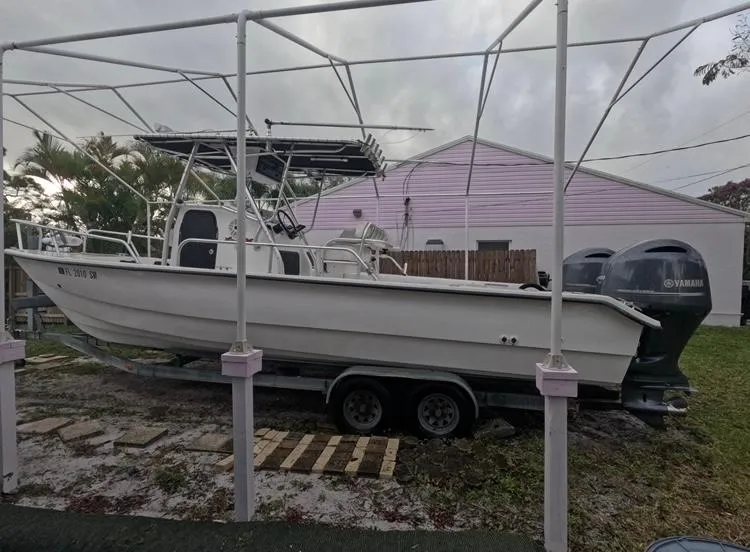 Slide: The Image of 2004 Twin Vee 26 Center Console boat on trailer, parked outdoors. - 3