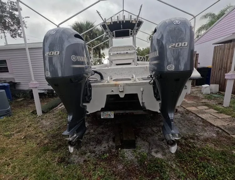 Slide: The Image of 2004 Twin Vee 26 Center Console with dual Yamaha 200 engines, parked outdoors. - 4