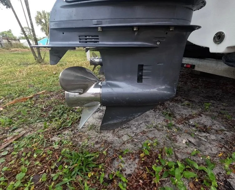 Slide: The Image of 2004 Twin Vee 26 Center Console boat engine propeller on grassy ground. - 49