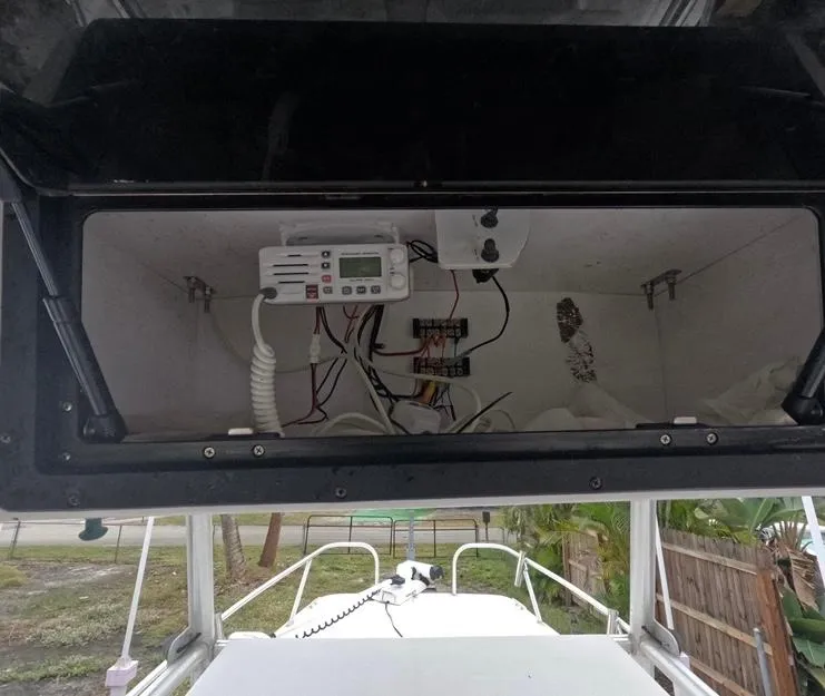 Slide: The Image of 2004 Twin Vee 26 Center Console electronics compartment with wiring and control panel. - 18