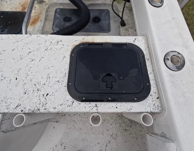Slide: The Image of 2004 Twin Vee 26 Center Console boat deck with storage hatch and rod holders. - 43