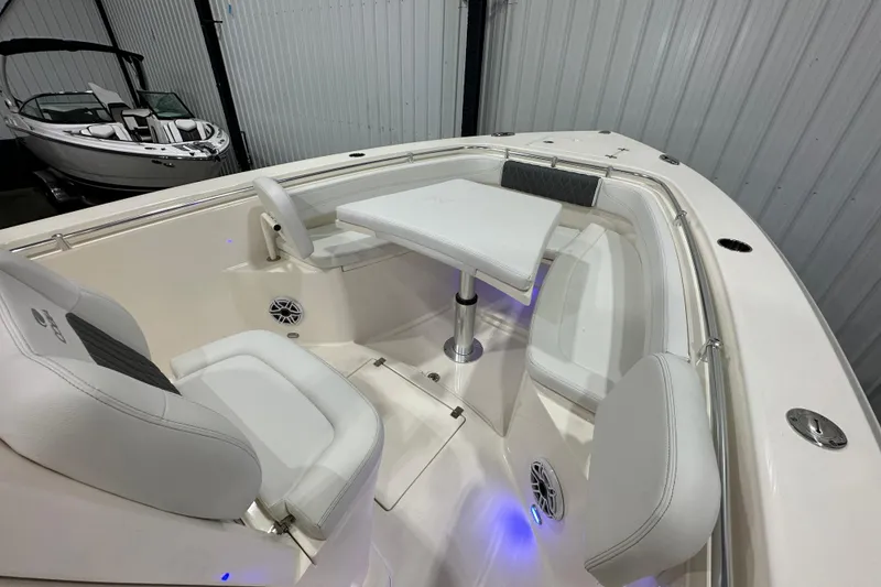 Slide: The Image of 2024 Cobia 301 Center Console boat interior with seating and table in a showroom. - 14