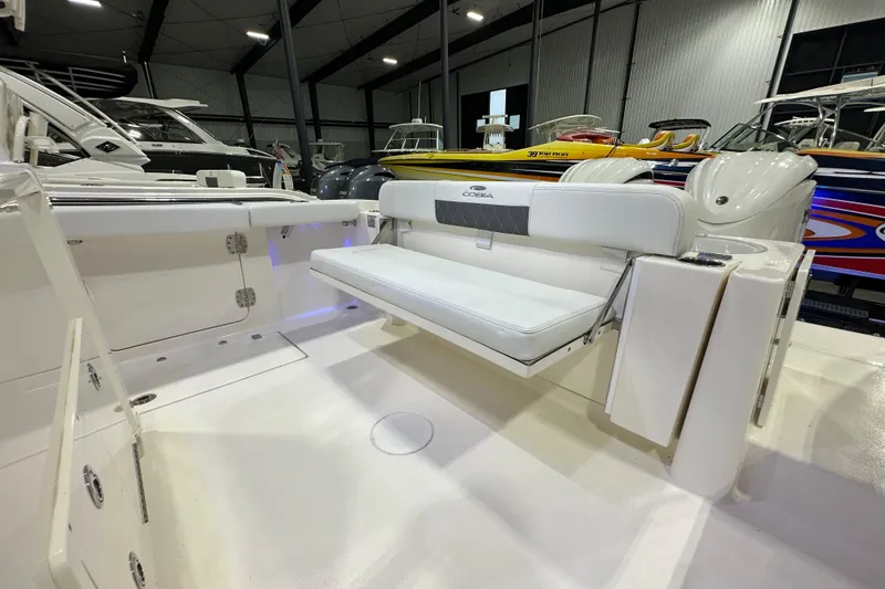 Slide: The Image of 2024 Cobia 301 Center Console boat interior with white seating in a showroom. - 5