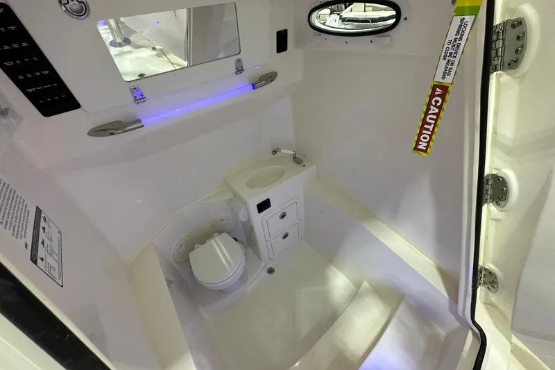 Slide: The Image of 2024 Cobia 301 Center Console interior cabin with toilet and sink. - 16