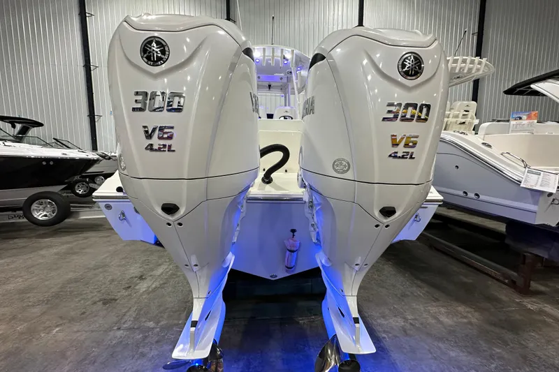 Slide: The Image of 2024 Cobia 301 Center Console with twin Yamaha 300 V6 4.2L engines in a showroom. - 2