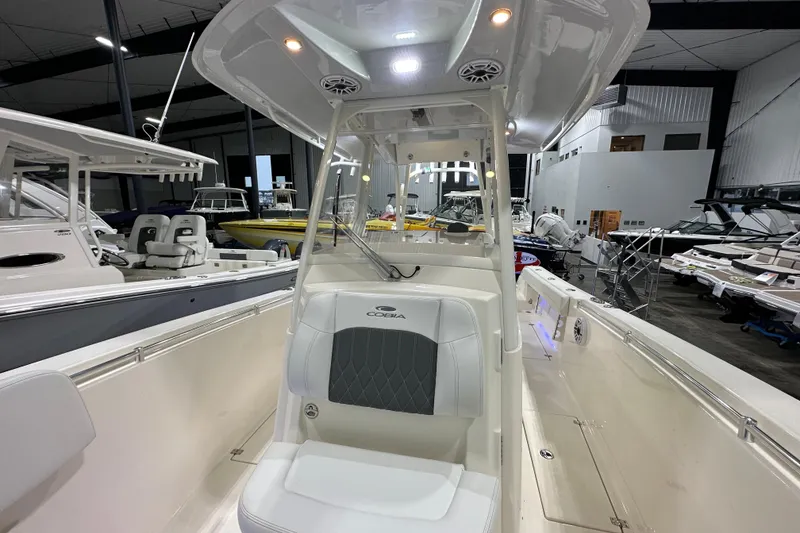 Slide: The Image of 2024 Cobia 301 Center Console boat interior in showroom, showcasing seating and helm area. - 15