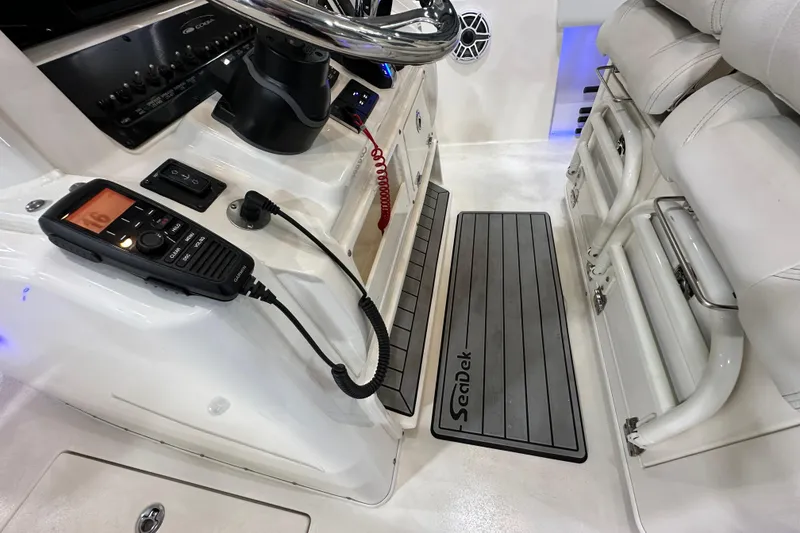 Slide: The Image of 2024 Cobia 301 Center Console interior with radio and SeaDek flooring. - 11