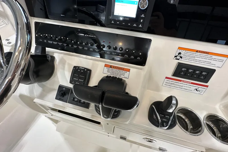 Slide: The Image of 2024 Cobia 301 Center Console dashboard with controls and warning labels. - 10