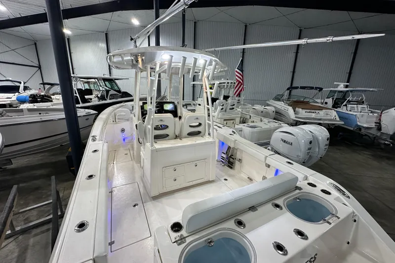 Slide: The Image of 2024 Cobia 301 Center Console boat in showroom, featuring dual Yamaha engines and modern design. - 4