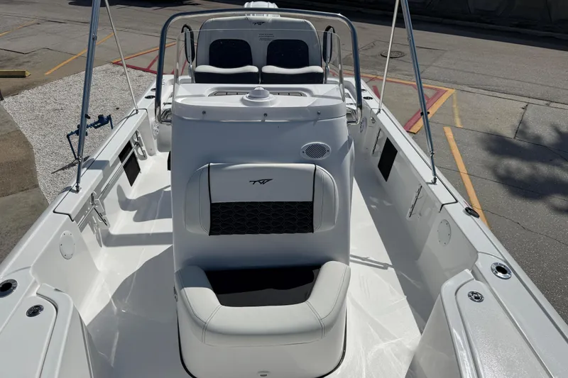 Slide: The Image of 2027 Tidewater 2110 Bay Max boat interior with seating and console, docked outdoors. - 5