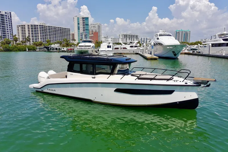 Slide: The Image of Modern Navan C30 boat docked in a marina, 2026 model, with city skyline background. - 6
