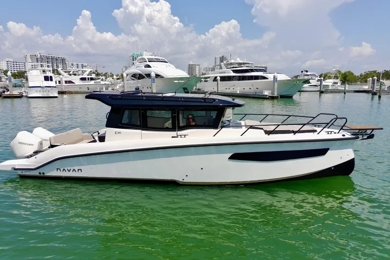 Slide: The Image of 2026 Navan C30 boat docked in marina, surrounded by luxury yachts. - 4