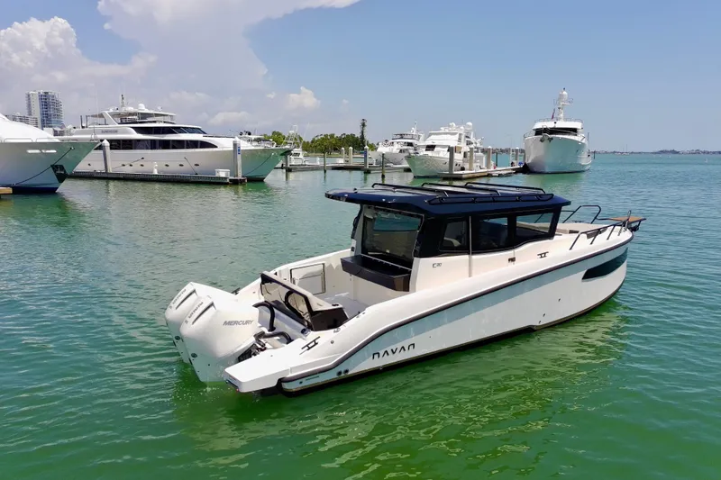 Slide: The Image of 2026 Navan C30 boat docked in a marina with luxury yachts in the background. - 10