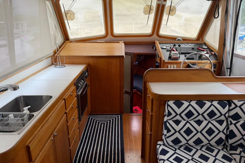 Slide: The Image of Interior of 1998 Sabreline 36 Fast Trawler with kitchen, steering area, and patterned seating. - 22