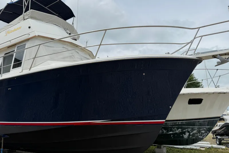 Slide: The Image of 1998 Sabreline 36 Fast Trawler with navy hull and white upper deck, docked outdoors. - 2